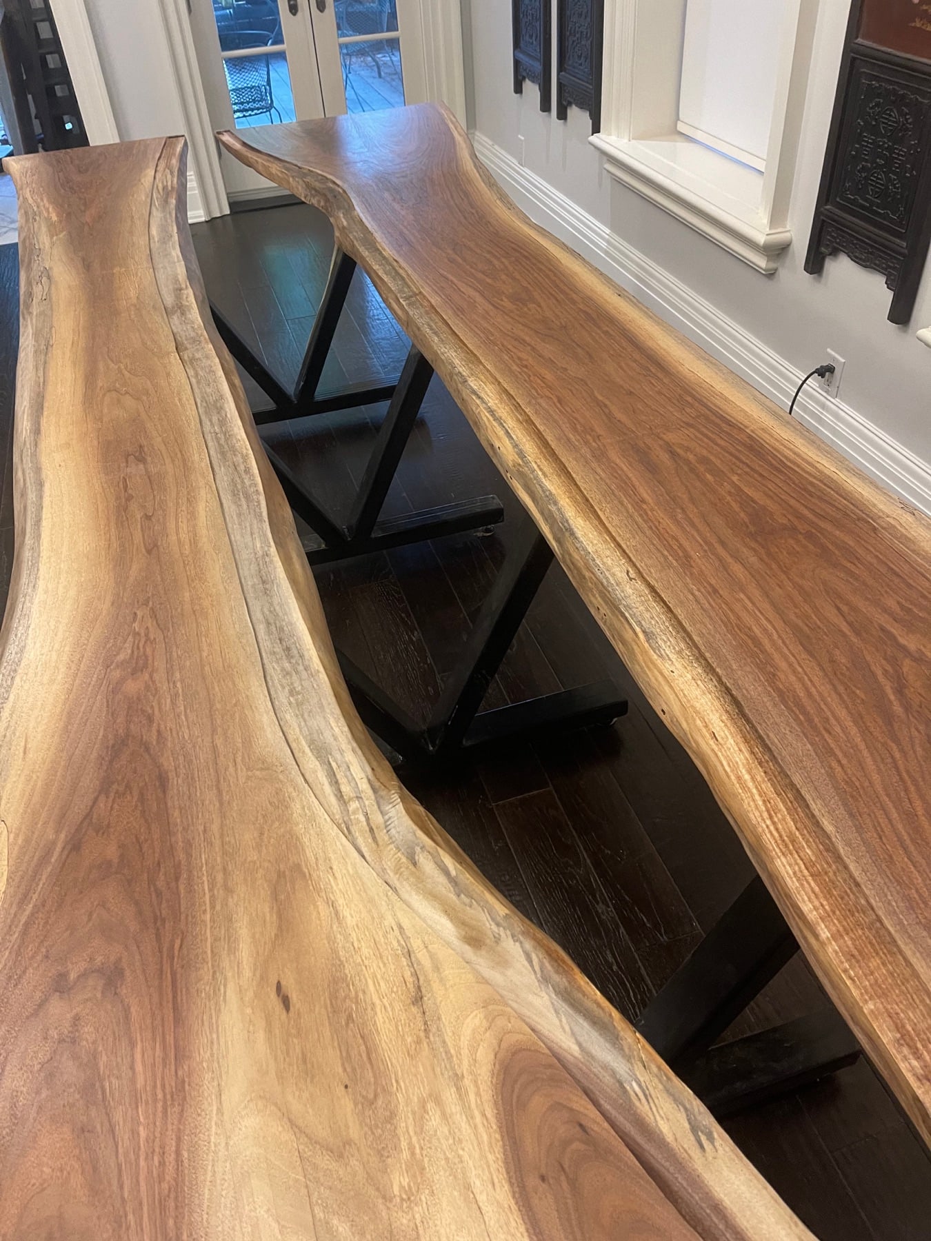 Close view of the wood grain, live edges, and black steel table base
